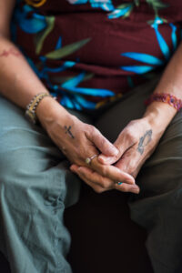 Sandra's hands with her fingers interlaced as her arms rest on her lap